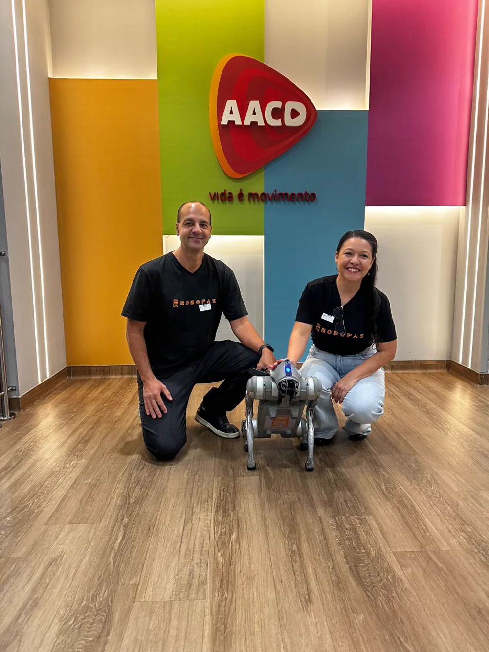 Sócios da RoboFaz ao lado do cão robô